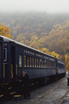 two men standing next to a train on the tracks