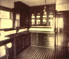 an old kitchen with black and white checkered flooring, cupboards and cabinets