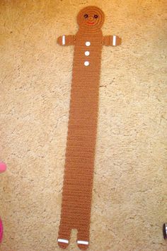 a crocheted ginger standing on the floor next to a pink teddy bear toy