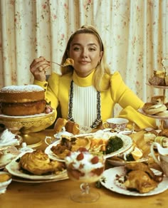 a woman is sitting at a table with many plates and bowls of food on it