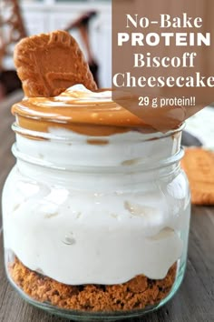 a glass jar filled with cheesecake and graham cracker crusts on top of a wooden table