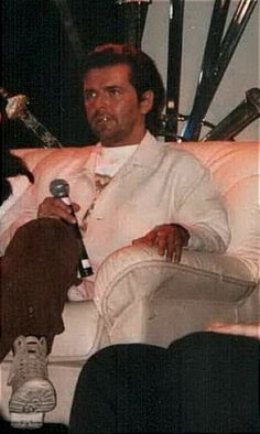 a man sitting in a chair holding a microphone