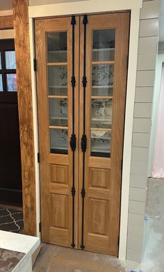 two wooden doors with glass inserts in a room