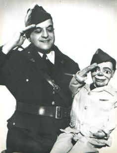 an old black and white photo of a man in uniform next to a young boy