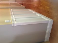 an empty hallway with hard wood flooring and white paneling on the side wall