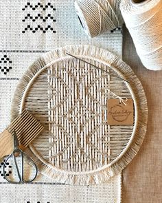 a basket with some yarn and scissors on it next to two skeins of thread