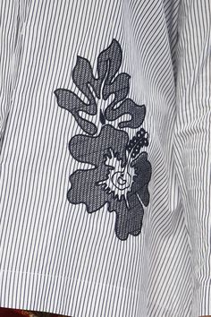 a close up of a person's shirt with flowers on the front and back