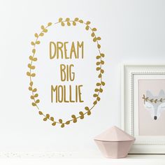 a wall decal with the words dream big mollie in gold foil on it