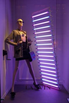 a mannequin is standing in front of a purple light