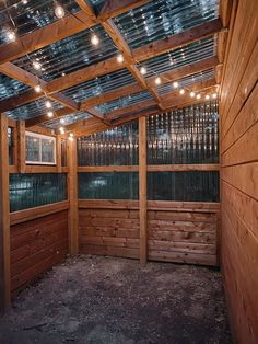 the inside of a building with wooden walls and lights hanging from it's ceiling