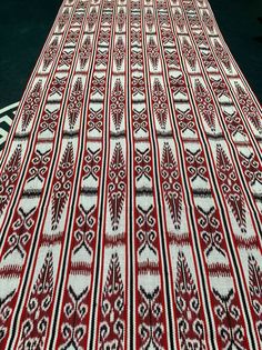 a large red and white rug sitting on top of a floor