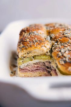 a close up of a sandwich in a white dish with other food items on it