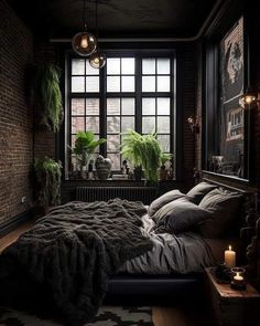 a bedroom with brick walls and dark colored bedding is lit by two hanging lights