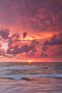 the sun is setting over the ocean with clouds