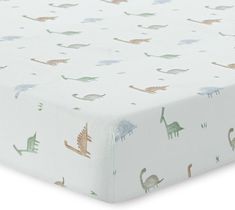 an image of a baby crib sheet with dinosaurs on it