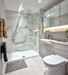 a white bathroom with marble walls and floor