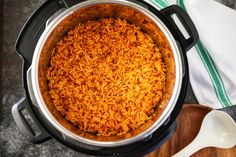 a large pot filled with rice on top of a wooden cutting board