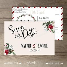 wedding save the date postcard with red flowers and greenery on it, sitting on top of a wooden table