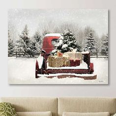 a red truck with presents in the back parked on snow covered ground next to trees