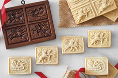 some cookies are sitting on a table next to a red ribbon and two pieces of chocolate