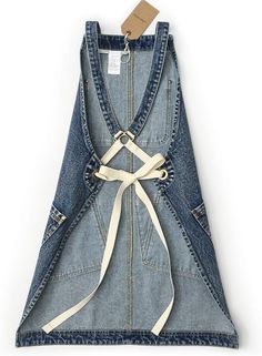 the back of a jean overall dress with a white ribbon tied around it's waist