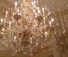 a chandelier hanging from the ceiling in a room with many lights on it