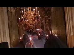 a person holding up a cell phone in front of a chandelier with candles