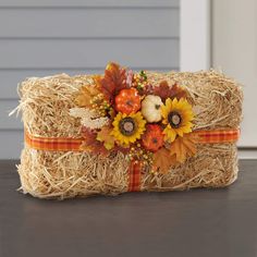 a hay bag with sunflowers and pumpkins on it sitting on a table