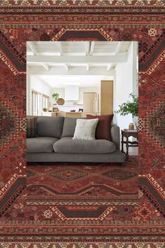 a living room with a couch and rugs on the floor in front of it