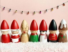 a group of wooden toy figurines sitting on top of a snow covered ground