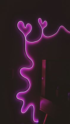 a purple neon sign with a lizard on it's side in the middle of a dark room