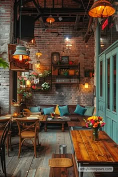 the interior of a restaurant with wooden tables and couches, hanging lights and potted plants