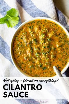 a white bowl filled with cilantro sauce on top of a blue and white towel