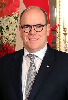 a man in a suit and tie smiling for the camera