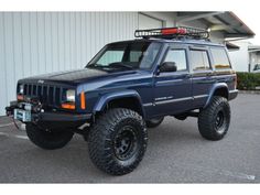 a blue jeep parked in front of a building