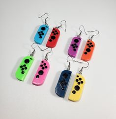 "These JoyCon earrings are perfect for any videogame enthusiast. Earrings measure approximately 1 3/8\" x 1/2\" Earrings are made with resin, so there may be small air bubbles. But we promise they won't take away from design and quality.  Ear hook is hypoallergenic, nickel free. If you want a different ear hook, let us know." Game Earrings, Crazy Earrings, 2 Earrings, Video Game Controller