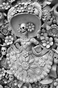 black and white photograph of an intricately decorated wall with skulls, flowers and other items