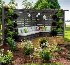 a couch sitting on top of a wooden bench next to a lush green park area