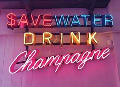 the neon sign for save water drink champagne