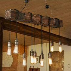 a bunch of lights that are hanging from a light fixture in a room with wood beams