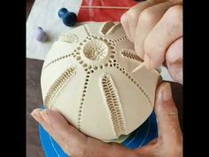 someone is making a decorative object out of clay