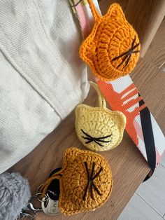 three crocheted keychains with cats on them sitting next to each other