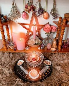 a table topped with candles and ornaments on top of a fur covered floor next to a wall