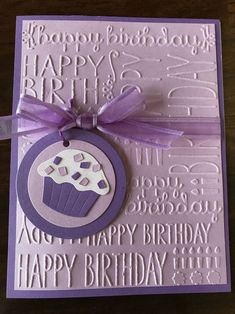 a birthday card with a cupcake on the front and purple ribbon tied around it