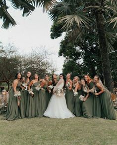 a group of women standing next to each other on top of a lush green field