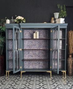 a blue cabinet with glass doors and shelves