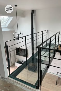 an empty room with glass railings and wood flooring