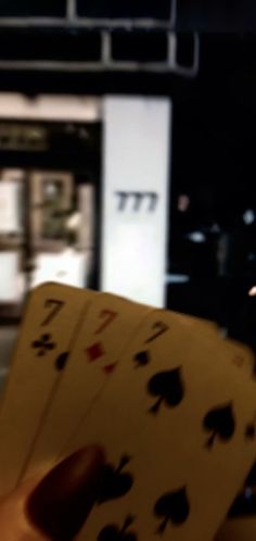 a person holding four playing cards in their hand