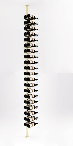 a wine rack filled with lots of bottles on top of a white table next to a wall