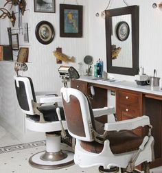 a barber chair sitting in front of a mirror next to a table with pictures on it